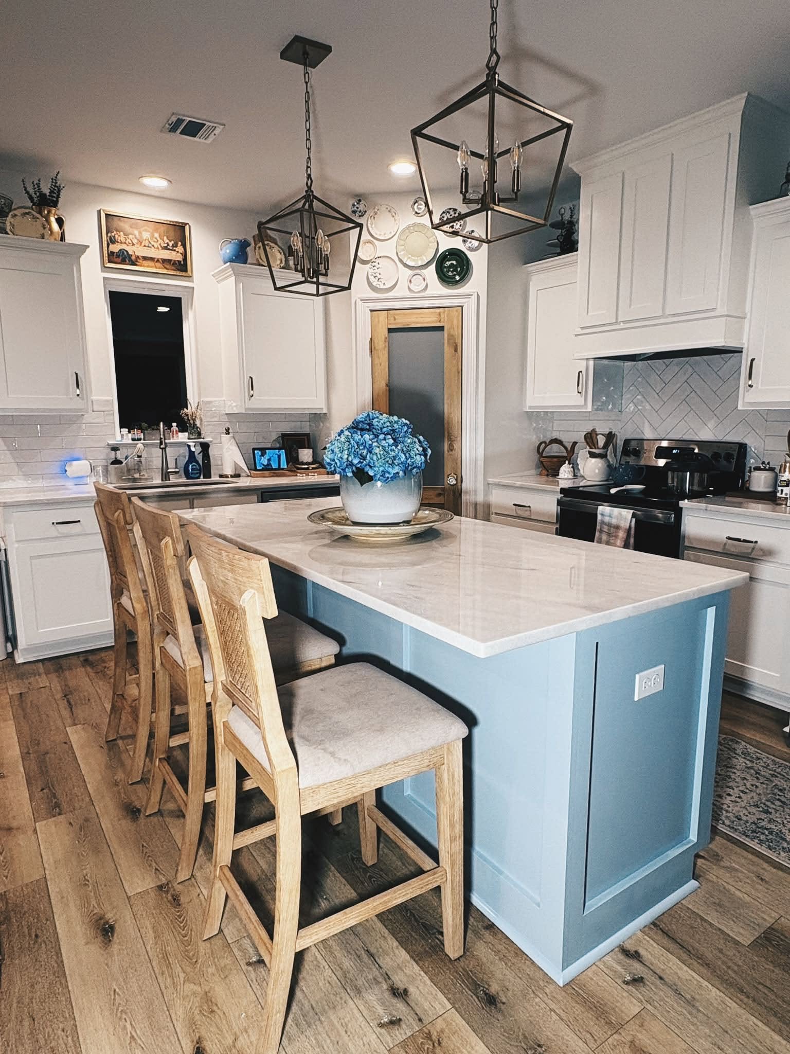 Kitchen after the pantry-door upgrade, with the wood door and white island