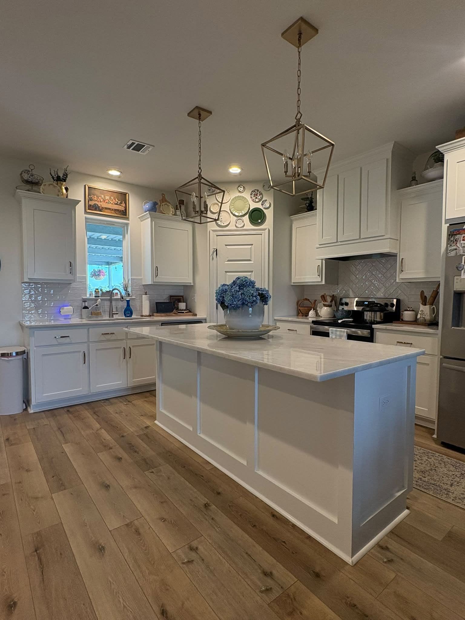 Kitchen before the pantry-door upgrade, with the white island and original door