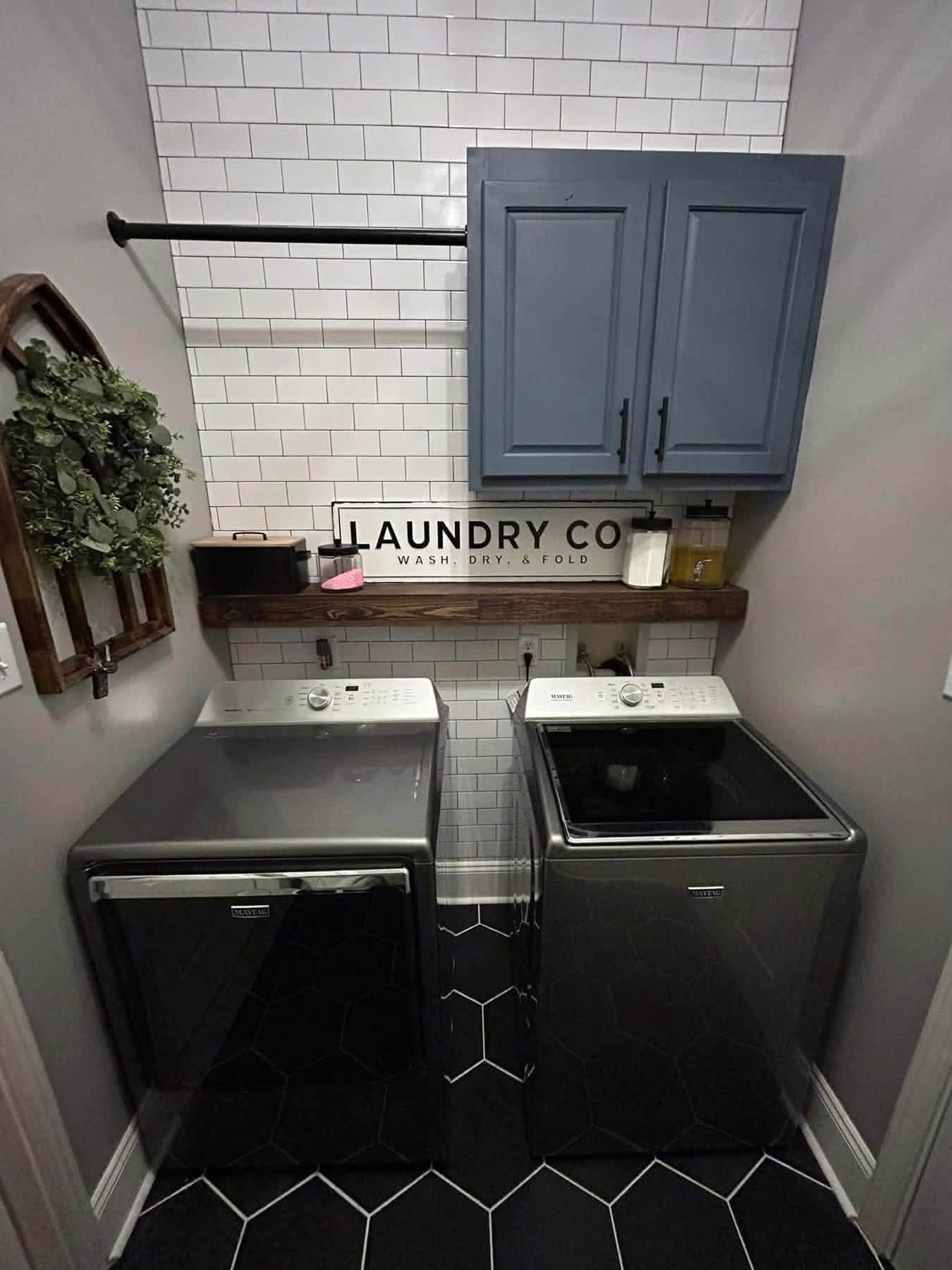 Finished laundry room with tile, shelving, cabinets, and new flooring